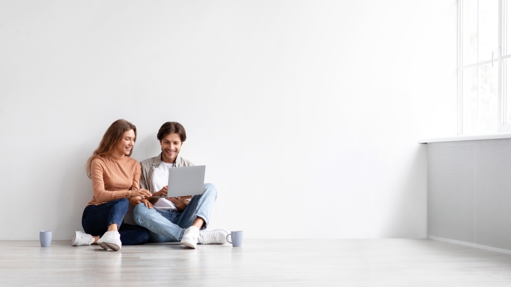 A couple is discussing something seen on the laptop screen